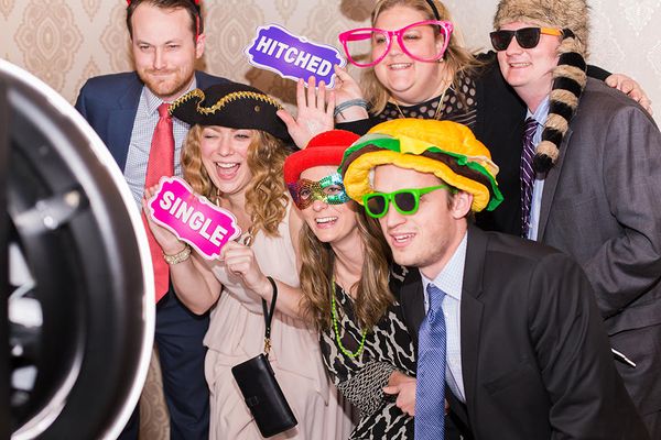 Skupinka přátel s rekvizitami ve fotobudce