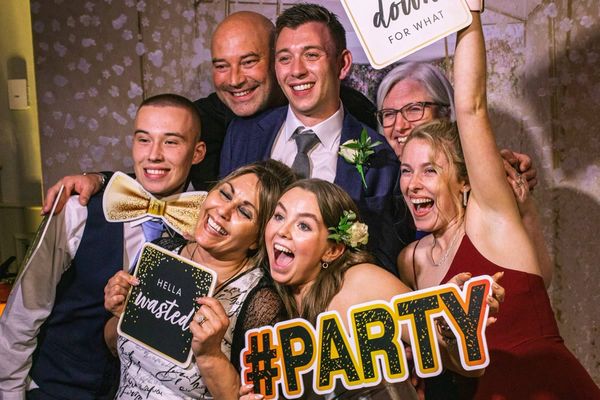 Skupina přátel ve fotobudce na svatbě